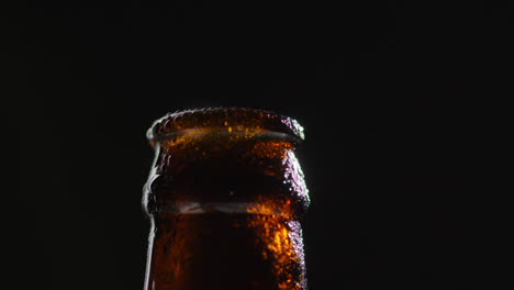 Close-Up-Of-Condensation-Droplets-On-Neck-Of-Revolving-Bottle-Of-Cold-Beer-Or-Soft-Drink-With-Water-Vapour-After-Opening-1